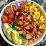 - 1 cup quinoa, thoroughly rinsed - 2 cups water or chicken broth - 2 boneless, skinless chicken breasts - 1 cup BBQ sauce - 1 cup cherry tomatoes, halved - 1 ripe avocado, sliced - 1 cup corn - 1 cup black beans, drained and rinsed - 1/2 cup red onion, thinly sliced - 1/4 cup fresh cilantro, chopped - Salt and pepper to taste - Olive oil for grilling You can swap quinoa for brown rice or couscous if you like. Use vegetable broth for a vegetarian version. Chicken can be replaced with grilled tofu or tempeh for a plant-based meal. If you want less sugar, choose a low-sugar BBQ sauce. Try using different beans like pinto or kidney beans instead of black beans. Each serving has about 450 calories. You get around 30 grams of protein from the chicken and beans. The dish also has healthy fats from avocado. It includes about 60 grams of carbs, mostly from quinoa and corn. This meal is rich in fiber, vitamins, and minerals. {{ingredient_image_2}} To start, rinse 1 cup of quinoa under cold water. This helps remove any bitterness. In a medium pot, bring 2 cups of water or chicken broth to a boil. Once boiling, add the rinsed quinoa. Give it a quick stir. Turn the heat down low and cover the pot. Let it simmer for about 15 minutes. The quinoa will absorb all the liquid. After 15 minutes, remove it from heat. Keep it covered for 5 more minutes. This step makes it fluffy. Finally, fluff the quinoa with a fork to separate the grains. While the quinoa cooks, prepare the chicken. Take 2 boneless, skinless chicken breasts. Season both sides with salt and pepper. Heat a drizzle of olive oil in a grill pan over medium-high heat. Place the chicken in the pan. Grill for about 6-7 minutes on each side. You want it nice and browned. Make sure it cooks fully, reaching an internal temperature of 165°F. After cooking, remove it from the heat. Brush each piece with 1 cup of BBQ sauce. Let it sit for a minute to caramelize. Then, slice the chicken into bite-sized strips. Now it’s time to put everything together. Take large serving bowls and add a base layer of quinoa. On top of the quinoa, arrange the sliced BBQ chicken. Next, add halved cherry tomatoes, sliced avocado, corn, black beans, and thinly sliced red onion. This makes the dish colorful and fresh. For the finishing touch, drizzle any leftover BBQ sauce over the bowls. Sprinkle with chopped cilantro for a burst of flavor. Serve right away for the best taste! To boost flavors in your BBQ Chicken Quinoa Bowls, try these tips: - Use chicken broth: Cook the quinoa in chicken broth instead of water. This adds depth to the flavor. - Homemade BBQ sauce: If time allows, make your own BBQ sauce. It tastes better and is healthier. - Add spices: Sprinkle in smoked paprika or cumin when cooking the chicken for a smoky flavor. Serving is just as important as cooking. Here are some fun ideas: - Colorful layers: Arrange the ingredients in separate sections on the bowls. This makes each layer pop and looks inviting. - Fresh herbs: Use chopped cilantro as a topping. It adds color and freshness. - Lime wedges: Serve with lime wedges on the side. A squeeze of lime gives a bright flavor boost. Juicy chicken is key to a great bowl. Follow these steps: - Proper seasoning: Use salt and pepper generously on both sides of the chicken. This enhances the taste. - Grill or pan-sear: Cook the chicken over medium-high heat. This helps it brown nicely while keeping it juicy. - Resting time: Let the chicken rest after cooking. This keeps the juices inside when you slice it. By using these tips, you can take your BBQ Chicken Quinoa Bowls to the next level! Pro Tips Perfectly Cooked Quinoa: Rinsing quinoa before cooking removes its natural coating called saponin, which can impart a bitter taste. Always rinse thoroughly for the best flavor. Juicy Chicken: Allow the chicken to rest for a few minutes after cooking before slicing. This helps retain the juices, making your chicken more flavorful and tender. BBQ Sauce Variations: Experiment with different BBQ sauces or make your own! Adding spices like smoked paprika or chipotle can give your dish a unique twist. Fresh Toppings: For added freshness, consider topping your bowls with a squeeze of lime juice or some diced jalapeños for a spicy kick. {{image_4}} You can easily make a vegetarian version of BBQ quinoa bowls. Instead of chicken, use grilled or roasted vegetables. Zucchini, bell peppers, and mushrooms work great. You can also use tofu or tempeh for protein. Marinate them in BBQ sauce before cooking for extra flavor. The BBQ sauce choice can change the taste of your bowls. Try a smoky sauce for a rich flavor. A spicy sauce adds a kick to the dish. For a sweet touch, use a honey-based BBQ sauce. If you prefer a healthier option, look for low-sugar or homemade sauces. They can enhance your meal without extra calories. Incorporating seasonal vegetables brings freshness to your bowls. Use asparagus in spring or butternut squash in fall. Roasted sweet potatoes add a sweet flavor, while fresh corn gives a nice crunch. You can mix and match veggies based on what is in season. This way, you get the best taste and support local farms. To store leftovers, let the BBQ Chicken Quinoa Bowls cool down first. Place them in an airtight container. Store in the fridge for up to three days. This keeps the flavors fresh. You can freeze these bowls for later use. Layer the quinoa and toppings in a freezer-safe container. Leave out the avocado, as it does not freeze well. You can keep them in the freezer for about three months. When ready, just thaw in the fridge overnight. When you want to enjoy your leftovers, reheat them gently. Use a microwave or a skillet. Add a splash of water or broth to keep it moist. Heat until warm, then enjoy the flavor again! Yes, you can use brown rice instead of quinoa. Just know that brown rice takes longer to cook. You will need about 40-45 minutes for it to soften. The flavor will change a bit, but it will still be tasty. You can store BBQ Chicken Quinoa Bowls in the fridge for up to three days. Make sure to keep them in an airtight container. The flavors may meld together, making it even better the next day! You can substitute chicken with tofu, beans, or grilled veggies. Tofu works well when marinated in BBQ sauce. Black beans or chickpeas add protein too. Just make sure to adjust cooking times based on what you choose. You learned how to make tasty BBQ Chicken Quinoa Bowls. We covered the full ingredient list and easy swaps. I shared step-by-step cooking tips for perfect quinoa and juicy chicken. We also explored fun ways to enhance flavors and serve. Plus, you discovered storage methods to keep your meal fresh. In summary, these bowls are adaptable and fun. Enjoy making them your own!