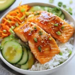 To create these tasty bowls, you need a few key ingredients. Here’s what you’ll need: - 2 salmon fillets - 1 cup jasmine rice - 2 cups vegetable broth (or water) - 1 avocado, sliced - 1 cup cucumber, julienned - 1 carrot, shredded - 2 green onions, chopped - Sesame seeds, for garnish - Salt and pepper to taste These ingredients form the base of your delicious meal. The marinade adds a burst of flavor to the salmon. Use these ingredients: - 2 tablespoons Sriracha sauce - 2 tablespoons honey - 1 tablespoon soy sauce - 1 teaspoon sesame oil Mix these together to make your salmon shine. Toppings make the bowls more fun and colorful. Here’s what to add: - Sliced avocado for creaminess - Julienned cucumber for crunch - Shredded carrot for sweetness - Chopped green onions for flavor - Sesame seeds for texture These toppings elevate the dish and make it look great! {{ingredient_image_2}} To start, gather your ingredients for the marinade. In a small bowl, mix together 2 tablespoons of Sriracha sauce, 2 tablespoons of honey, 1 tablespoon of soy sauce, and 1 teaspoon of sesame oil. Whisk this mixture until it is smooth. Next, take your 2 salmon fillets and place them skin-side down in a shallow dish. Pour the marinade over the salmon, making sure each piece is covered. Cover the dish and let it sit for at least 15 minutes. This will help the salmon soak up all the tasty flavors. While the salmon is marinating, rinse 1 cup of jasmine rice in cold water. Use a fine-mesh sieve to wash until the water runs clear. This step removes excess starch and helps the rice stay fluffy. In a medium saucepan, bring 2 cups of vegetable broth to a boil. Add the rinsed rice and a pinch of salt. Reduce the heat to low, cover the pot, and let it simmer for about 15 minutes. The rice will absorb all the liquid and become tender. Once done, fluff the rice with a fork and set it aside. Preheat your oven to 400°F (200°C). Line a baking sheet with parchment paper. This makes cleanup easy. Place the marinated salmon on the baking sheet, skin-side down. Bake in the preheated oven for 12 to 15 minutes. The salmon is ready when it flakes easily with a fork. While the salmon bakes, prepare your veggies. In each bowl, add a scoop of fluffy jasmine rice as the base. On top of the rice, layer sliced avocado, julienned cucumber, shredded carrot, and chopped green onions. These toppings add great flavor and texture to your bowl. Once the salmon is done, carefully place a fillet on each rice bowl. Drizzle any leftover marinade from the baking sheet over the salmon for extra flavor. For a nice finish, sprinkle sesame seeds on top. You can also add salt and pepper to taste. A squeeze of lime juice over the bowls adds a fresh touch right before serving. Enjoy your colorful and tasty Sriracha Honey Salmon Rice Bowls! To get the best salmon, marinate it well. Use Sriracha, honey, soy sauce, and sesame oil. Let it soak for at least 15 minutes. This brings out the flavors. Bake it at 400°F (200°C) for 12-15 minutes. The salmon should flake easily when done. If it looks bright pink inside, it's ready! For perfect jasmine rice, rinse it first. This removes extra starch. Use cold water until it runs clear. Boil 2 cups of vegetable broth. Add 1 cup of rinsed rice and a pinch of salt. Cover it and simmer on low heat for about 15 minutes. Once the water is gone, fluff it with a fork. Make your bowls look great! Use clear glass dishes to show off the colors. Start with a scoop of rice as the base. Add sliced avocado, cucumber, and shredded carrot on top. Place the cooked salmon right in the center. Drizzle leftover marinade over the salmon. Finish with a sprinkle of sesame seeds and extra green onions. A lime wedge on the side adds a nice touch too! Pro Tips Marination Mastery: Allow the salmon to marinate for at least 30 minutes for deeper flavor absorption. For even more intensity, marinate overnight in the refrigerator. Rice Perfection: Rinse the jasmine rice thoroughly to achieve the perfect fluffy texture. This step removes excess starch, preventing the rice from becoming gummy. Salmon Cooking Tip: For best results, check the salmon at the 12-minute mark. Every oven is different, and you want to avoid overcooking for a moist, flaky texture. Presentation Matters: Serve the bowls in clear glass dishes to highlight the vibrant colors and layers of ingredients, making the dish as visually appealing as it is delicious. {{image_4}} You can easily swap ingredients to fit your diet. If you want a vegan option, use tofu instead of salmon. Tofu absorbs flavors well and gives a nice texture. For a gluten-free meal, replace soy sauce with tamari. You can also use cauliflower rice instead of jasmine rice for a low-carb option. This change keeps the dish light yet satisfying. If you’re not a fan of salmon, try other proteins. Chicken breast works well with the same marinade. Shrimp is another tasty choice, cooking quickly and packing a punch. For a plant-based protein, chickpeas are a great substitute. Just roast them until crispy for added texture. Each option keeps the dish fun and fresh! Want to spice things up? Add fresh herbs like cilantro or basil to the bowls. A squeeze of lime adds zest and brightness. You can also mix in some chopped peanuts for crunch. If you love heat, add more Sriracha or even a dash of chili flakes. Each enhancement takes your rice bowl to the next level! To store leftovers, let the rice bowls cool down. Place the salmon and rice in separate airtight containers. Add the veggies on top, but keep them separate if possible. This helps them stay fresh. Use the leftovers within three days for the best taste. When ready to eat, reheat the salmon in the oven at 350°F (175°C) for about 10 minutes. You can also microwave the salmon for 1-2 minutes on medium power. For rice, add a splash of water, cover, and microwave for about 1 minute. This keeps the rice fluffy and moist. Meal prep makes this dish easy for busy days. Cook a batch of rice and store it in the fridge. Marinate the salmon ahead of time and keep it in the fridge for up to 24 hours. Chop the veggies and store them in containers. When it’s time to eat, assemble the bowls quickly. This way, you can enjoy a tasty meal without the fuss! Yes, you can use frozen salmon. Just make sure to thaw it first. Place the frozen salmon in the fridge overnight or under cold water for quicker thawing. Once thawed, you can marinate and bake it as usual. If you don’t have jasmine rice, use basmati or long-grain rice. Quinoa is also a great choice for a healthy twist. Both options provide a nice texture and flavor that complements the salmon. Yes, you can easily make this dish gluten-free. Replace regular soy sauce with gluten-free soy sauce or tamari. Check the labels on the Sriracha and honey to ensure they are gluten-free as well. Sriracha has a moderate heat level. If you want less spice, use less Sriracha in the marinade. You can also mix it with a bit of ketchup or honey to balance the heat. This will still give you the delicious flavor without too much kick. In this article, we explored how to make Sriracha Honey Salmon Rice Bowls. We covered the main ingredients, marinating tips, and how to cook the salmon and rice perfectly. I shared helpful tips for presentation and discussed variations and storage for leftovers. These bowls are simple, tasty, and flexible for anyone. Try this recipe for a meal that’s easy to enjoy!