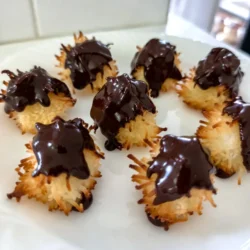 To make these delicious treats, gather these main ingredients: - 3 cups shredded sweetened coconut - 1/2 cup granulated sugar - 1/4 cup all-purpose flour - 1/4 teaspoon salt - 2 large egg whites - 1 teaspoon vanilla extract - 1 cup semi-sweet chocolate chips - 1 teaspoon coconut oil These ingredients form the base for your macaroons. The shredded coconut gives a chewy texture, while the sugar adds sweetness. The flour helps bind everything together. If you need to make swaps, here are some common substitutions: - Use unsweetened coconut for less sweetness. - Replace granulated sugar with brown sugar for a richer flavor. - Almond flour can work instead of all-purpose flour for a gluten-free option. - Use egg substitutes like flaxseed meal or applesauce for a vegan version. - Swap vanilla extract with almond extract for a different flavor twist. These alternatives can help you adapt the recipe based on what you have on hand or dietary needs. You can make your macaroons even more fun with these optional toppings and fillings: - Drizzle extra melted chocolate on top for a fancy look. - Sprinkle toasted coconut for added texture and flavor. - Add a sprinkle of sea salt to enhance sweetness. - Fill the center with a bit of jam, caramel, or nut butter for a surprise. - Consider dipping the sides in nuts or sprinkles for extra crunch. These options let you customize your macaroons, making each batch unique and exciting! {{ingredient_image_2}} Start by setting your oven to 325°F (160°C). This is the perfect temperature for baking macaroons. Next, line a baking sheet with parchment paper. This will keep your macaroons from sticking and make cleanup easy. In a large bowl, add 3 cups of shredded sweetened coconut. Then, mix in 1/2 cup of granulated sugar, 1/4 cup of all-purpose flour, and 1/4 teaspoon of salt. Stir these dry ingredients well. You want everything mixed evenly for a tasty result. In a separate bowl, whisk 2 large egg whites with 1 teaspoon of vanilla extract. Keep whisking until the mixture is frothy. Don’t whisk until stiff peaks form; just frothy is enough. Then, gently fold the egg whites into your coconut mixture. Use a spatula or spoon to combine them. The mixture should feel sticky and hold together when pressed. Take a cookie scoop or your hands to form small mounds. Each mound should be about 1.5 inches tall. Place them on the prepared baking sheet. Make sure to leave space between each mound. This allows them room to expand while baking. Bake in your preheated oven for 20-25 minutes. They should turn a lovely light golden brown. While the macaroons cool, it’s time to melt the chocolate. In a microwave-safe bowl, combine 1 cup of semi-sweet chocolate chips with 1 teaspoon of coconut oil. Heat this mixture in 20-second intervals, stirring each time. Continue until it’s smooth and combined. Once the macaroons are cool, dip the bottoms into the melted chocolate. Allow any extra chocolate to drip off. Place the dipped macaroons back on the parchment paper. For a pretty finish, drizzle more melted chocolate over the tops using a fork. Serve your finished macaroons on a tiered dessert stand. You can even sprinkle some extra shredded coconut on top for extra flair. Enjoy your delightful treats! To make the best macaroons, you want a chewy inside and a crisp outside. Use fresh shredded coconut. This gives great flavor and texture. When mixing, fold the egg whites gently. This keeps air in the mixture, making your macaroons light. If you overmix, they can become dense. Pay attention to baking time. If you bake them too long, they turn hard. Look for a light golden color on the outside. This means they are just right. To keep your macaroons fresh, store them in an airtight container. Place parchment paper between layers to prevent sticking. They can stay fresh for about a week at room temperature. If you want them to last longer, freeze them. Wrap each macaroon in plastic wrap, then place them in a freezer bag. They can last up to three months in the freezer. Thaw them at room temperature when you are ready to enjoy them again. Sometimes, macaroons may not turn out as expected. If they spread too much, it could be due to too much egg white. Ensure you measure carefully. If they are too dry, try adding a bit more egg white next time. If they burn quickly, check your oven temperature. An oven thermometer can help you get it right. Lastly, if they stick to the pan, make sure to use parchment paper. This helps them lift off easily after baking. Pro Tips Use Fresh Coconut: For an even more vibrant flavor, consider using fresh coconut instead of shredded. It adds a delightful texture and taste. Chill Before Baking: Chilling the formed macaroons in the fridge for 15-20 minutes before baking can help them maintain their shape better. Experiment with Flavors: Add a pinch of almond extract or orange zest to the mixture for a unique flavor twist that complements the coconut and chocolate. Store Properly: Keep leftover macaroons in an airtight container at room temperature for up to a week, or in the fridge for longer-lasting freshness. {{image_4}} You can easily mix up the flavors of your macaroons. Try adding a bit of almond extract for a nutty taste. You can also fold in some lemon zest for a bright, fresh flavor. Another idea is to stir in mini chocolate chips for extra sweetness. These simple changes make your treats more exciting and fun to eat. While semi-sweet chocolate is great, you can try dark or milk chocolate too. Dark chocolate offers a rich taste, while milk chocolate adds creaminess. For a unique twist, use white chocolate. Just remember to adjust the amount of sugar if you use sweeter chocolate. Each type gives your macaroons a new twist. Adding nuts or dried fruits can enhance your macaroons. Chopped almonds, walnuts, or pecans add a nice crunch. You can also use dried fruits like cranberries or apricots for a chewy texture. Just be sure to chop them small so they mix well. This way, every bite is a delightful surprise. To keep your macaroons fresh, store them in an airtight container. This helps keep moisture out. Place parchment paper between layers if you stack them. This prevents sticking. Keep the container in a cool, dry place. Avoid direct sunlight to maintain their texture and taste. You can freeze your macaroons for longer storage. First, let them cool completely. Then, place them in a single layer on a baking sheet. Freeze them for about an hour. After that, transfer the macaroons to a freezer-safe bag or container. Make sure to remove as much air as possible. They can stay frozen for up to three months. When ready to eat, just thaw them at room temperature. Homemade macaroons last about one week at room temperature. If stored properly in the fridge, they can last up to two weeks. If you freeze them, you can enjoy them for months. Always check for any signs of spoilage before eating. Freshness is key to enjoying their wonderful coconut and chocolate flavor! To make great macaroons, follow these tips: - Use fresh, sweetened shredded coconut. - Measure ingredients accurately. - Whisk egg whites to a frothy stage, not stiff peaks. - Fold the egg whites gently into the coconut mix. - Space out the mounds on the baking sheet. These steps help create a light and chewy texture. Yes, you can! To make them gluten-free, you just need to use gluten-free flour. Substitute all-purpose flour with a gluten-free blend. This small change keeps your macaroons safe for everyone. To keep your macaroons from spreading, follow these guidelines: - Space the mounds well on the baking sheet. - Chill the dough for a bit before baking. - Make sure your egg whites are not over-whipped. These tips help them hold their shape during baking. Macaroons and macarons look similar but are quite different. - Macaroons are made with shredded coconut and are chewy. - Macarons are delicate meringue cookies filled with cream. Knowing this helps in choosing the right treat for your cravings. To achieve extra chewiness, do the following: - Use a bit more coconut than flour. - Bake them just until golden, not too long. - Let them cool fully on the baking sheet before moving. These steps ensure a soft and chewy bite every time. You now have all the tools to make perfect chocolate dipped coconut macaroons. We explored key ingredients and helpful tips to ensure great texture and flavor. With easy steps and variations, you can customize your treat. Remember, practice makes perfect. Your efforts will pay off with smiles from family and friends. Enjoy your baking journey and share the joy of these sweet treats!